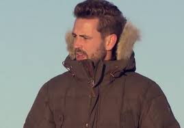 NIck is standing around in a parka, looking confused.