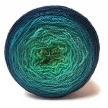 A cake of gradiant yarn that transistions from deep blue to pale green.