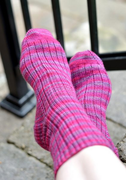 A close up on a pair of pink and purple ribbed socks.