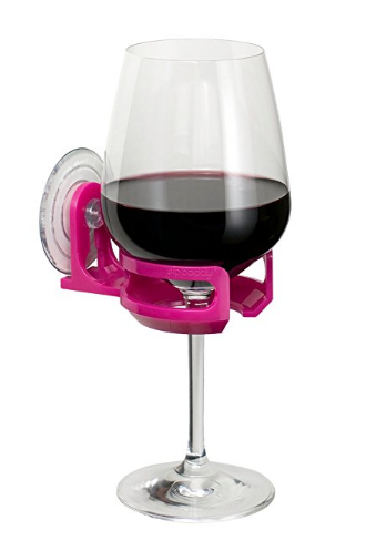 Close up of a glass of red wine in the shower caddy which suction cups to the wall of the tub or shower. 