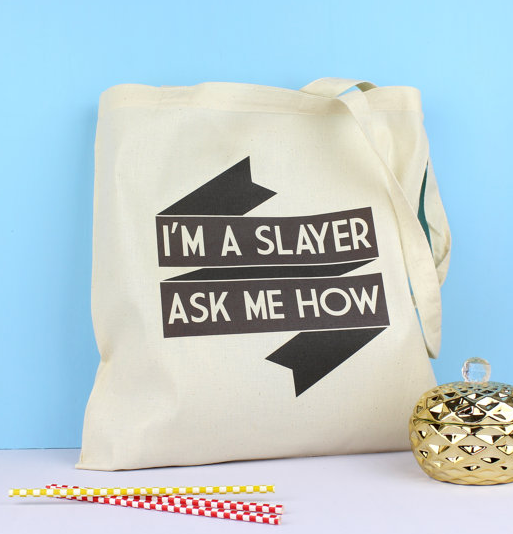 Canvas totebag with black ribbon that reads I'm a Slayer Ask me How