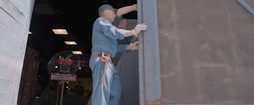 A push through shot, coming into the studio from the outside, ending on Joan and Bette, in their chairs and seemingly laughing together. It's an act.