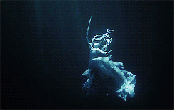 A Lady underwater, holding Excalibur aloft Her hair and gown swirl around her like a jellyfishs tentacles.