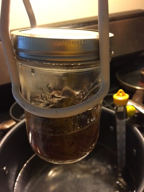 The jar of cooked beef and juices just pulled from the water bath