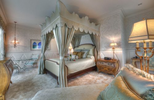 The fairytale suite at Disneyland resort, featuring a canopy bed and a lounge that looks out towards the fireworks show