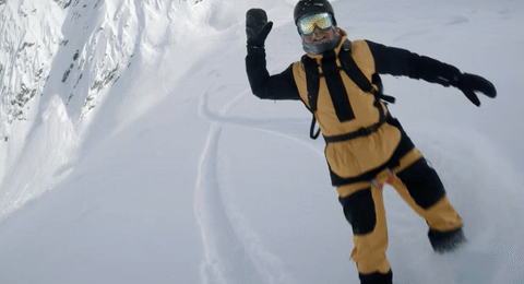 A gif of two snowboarders high fiving