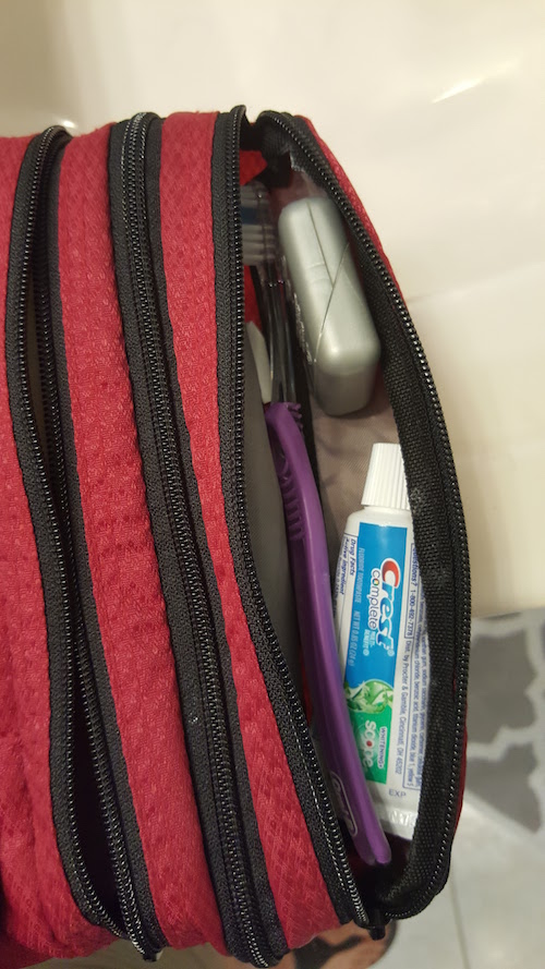 Far right slender pocket holds toothbrush, toothpaste, and floss