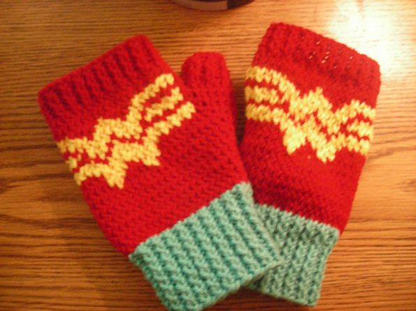 A pair of red fingerless gloves with the Wonder Woman logo across the back of the hands.