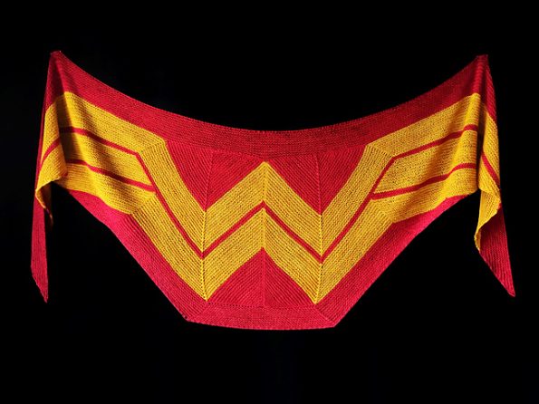 A modified triangular shawl with a red background and the Wonder Woman logo in gold.