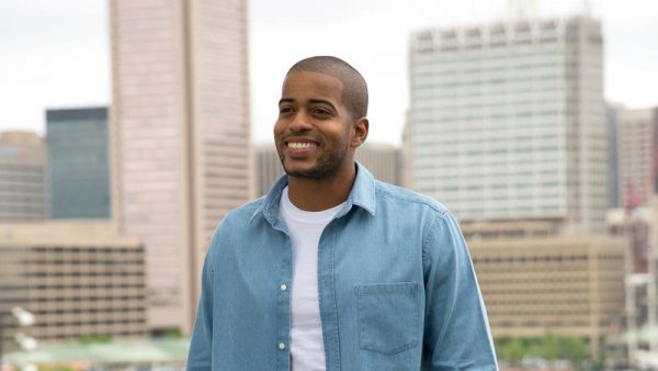 Eric stands smiling against the Baltimore skyline.