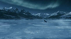 Belle runs across the frozen lake, with the Beast bounding behind her