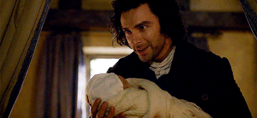 Ross, holding tiny baby Clowance, and grinning. It's adorable how happy he is.
