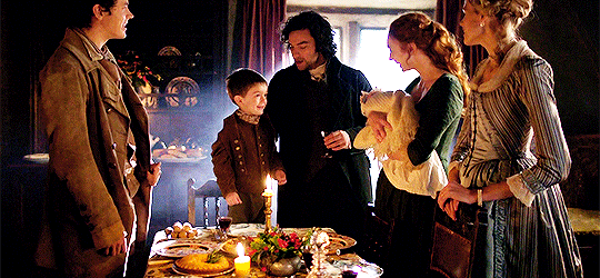 A Poldark Christmas, with Drake, Jeremy, Ross, D, Clowance, and Caroline, standing around the table Jeremy is standing on his chair and looks SO PROUD of himself singing.