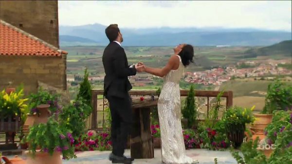 Rachel and Bryan join hands, giddy, atop a castle in Spain