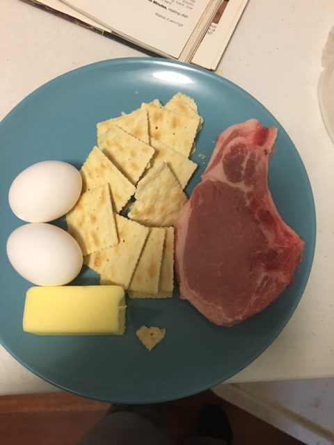 Ingredients picture! Two eggs, half a stick of butter, saltine crackers, and a single pork chop