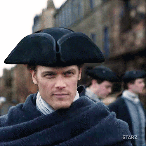 Jamie, walking through the streets of Edinburgh, in his tricorn hat and a blue wool wrap.