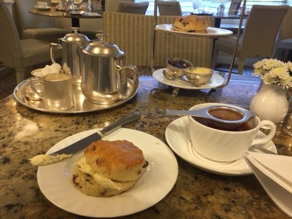  Tea pot, scones, cream, and a little tea strainer over the cup. Super civilized.