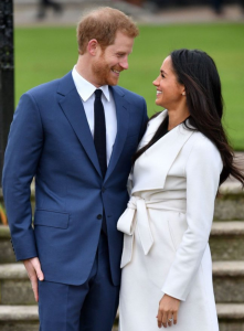 Prince Harry and Meghan Markle smiling at ach other at photo call yesterday