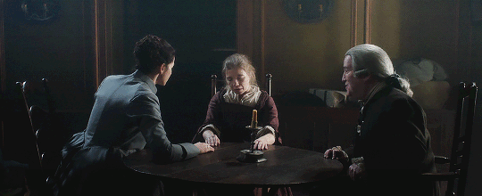 Claire, Margaret Campbell, and Archie Campbell sitting at a table. Margaret is catatonic.