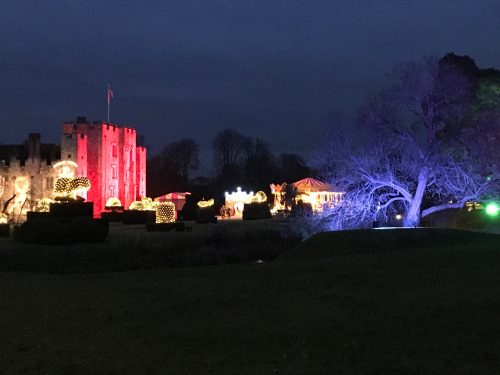 Castle and trees lit up with colored floodlights