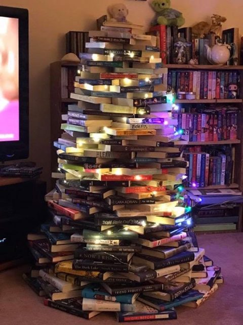 A tree assembled out of books and strung with lights.