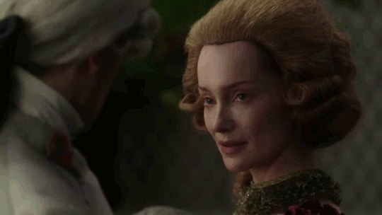 Geillis in her hard-front wig, eyeing Lord John.