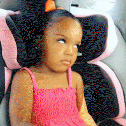 A little girl in a car seat rolls her eyes