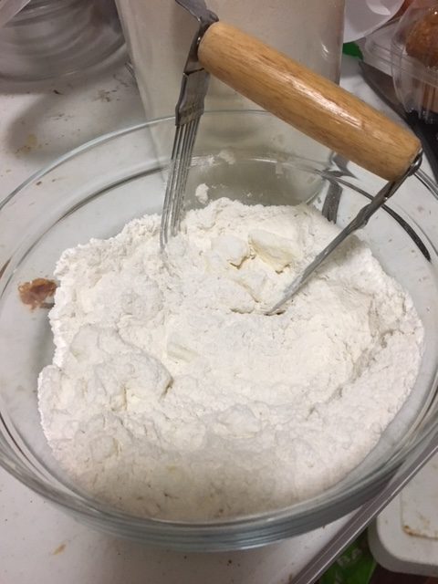 cutting butter into flour with a pastry cutter 