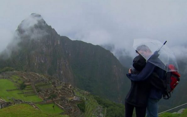 Arie and Lauren cuddle under an umbrella overlooking I believe Machu Picchu. 