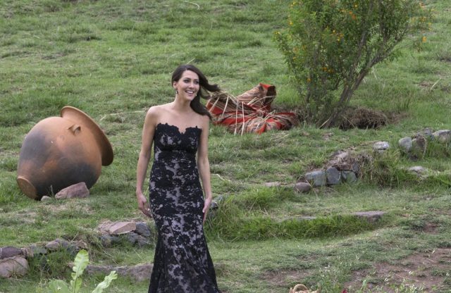 Becca approaches Arie. She's wearing a strapless black lace gown.
