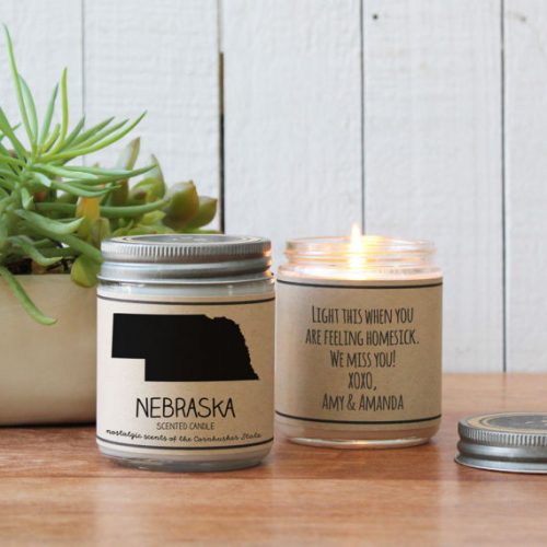 Hello You Candles - Nebraska. A white candle in a white jar. The label has a silhouette of Nebraska and a metal lid.