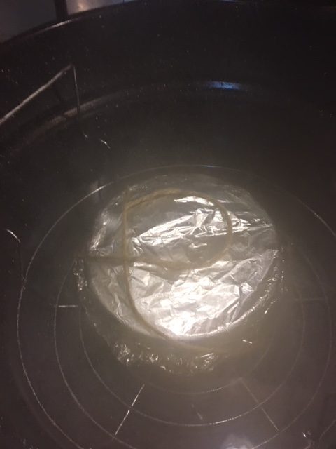 the pudding basin in the steaming pot.