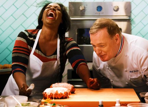 Jacques and contestant Toni look at her donuts. Toni is cracking up after Jacques told her he thought she was making baked potatoes with the way her donuts looked.