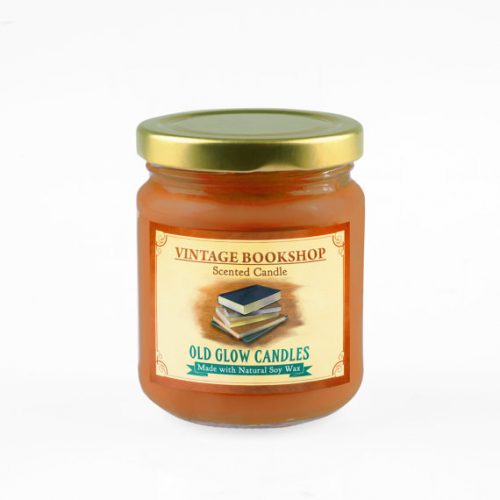 Old Glow Candles in Vintage Bookshop scent. A deep orange candle in a glass jar. The label has a stack of books on it.