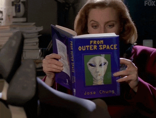 Dana Scully, heels on the desk reading From Outer Space with very wide eyes and a raised eyebrow