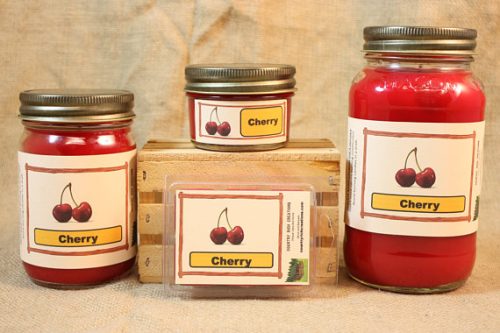 A selection of red candles in a cherry scent. There are three sizes of candles and one pack of wax melts.