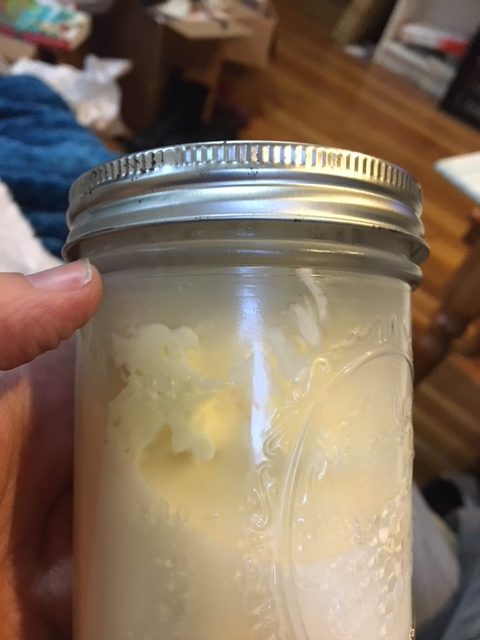 Jar with buttermilk and visible lumps of butter