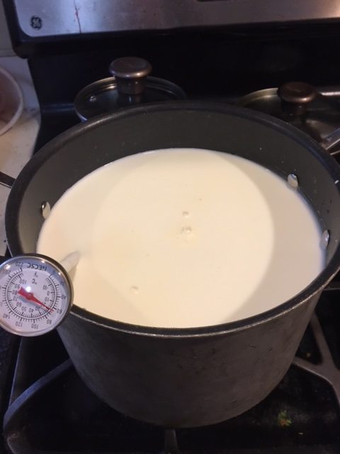Milk from happy cows in the pot on the stove.