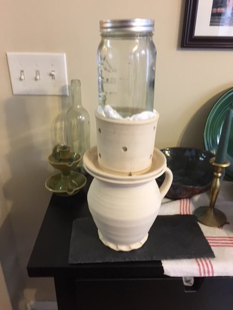 Curds in the mold, with a full mason jar of water as a weight.