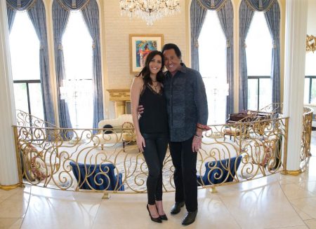 Becca stands next to Wayne Newton in what I'm assuming is his mansion