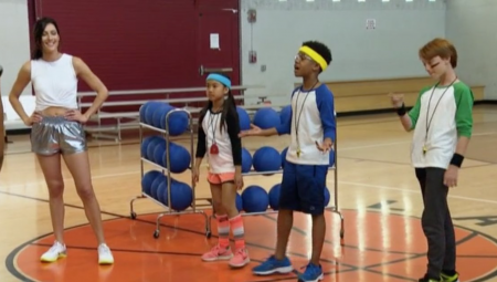 Becca and three school kids stand in front of a rack of dodgeballs