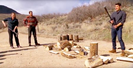 John splits a log while their instructors look on