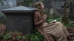 Mary, sitting against her mother's tombstone, looking oensive
