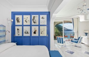 photo shows a room including the bed, art, and the terrace with ocean view