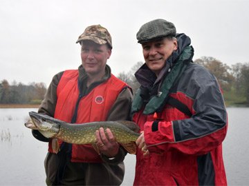 Derry, out on a lake, proudly showing off the large fish he caught.