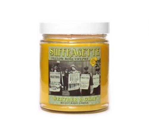 A yellow candle in a clear jar. The label has an old black and white photo of protesting suffragettes.