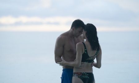 Becca and Blake stand on a beach together