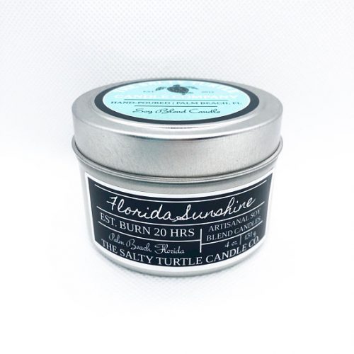 A metal candle tin with label in black, white, and light blue.