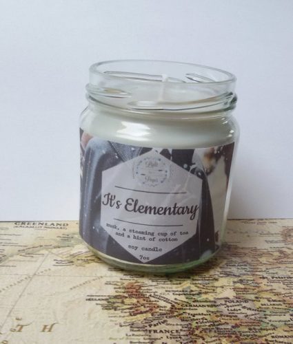 A white candle in a clear jar displayed on a map.