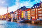 Scenic summer sunset view of Nyhavn pier with color buildings, ships, yachts and other boats in the Old Town of Copenhagen, Denmark